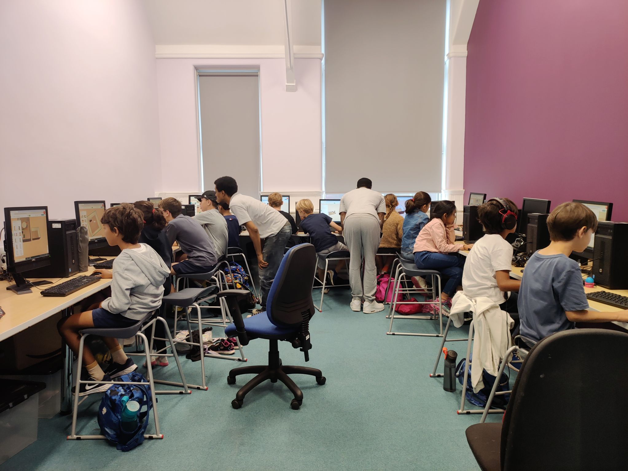 Full classroom of kids coding at computers